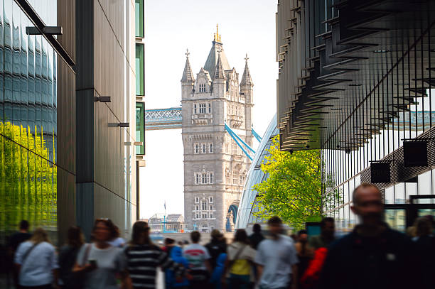 People in motion in a street with Tower Bridge in the background. London, England.