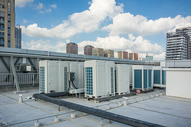 istock Modern Urban Rooftop with Air Conditioning Units Against a Blue Sky 2214041726