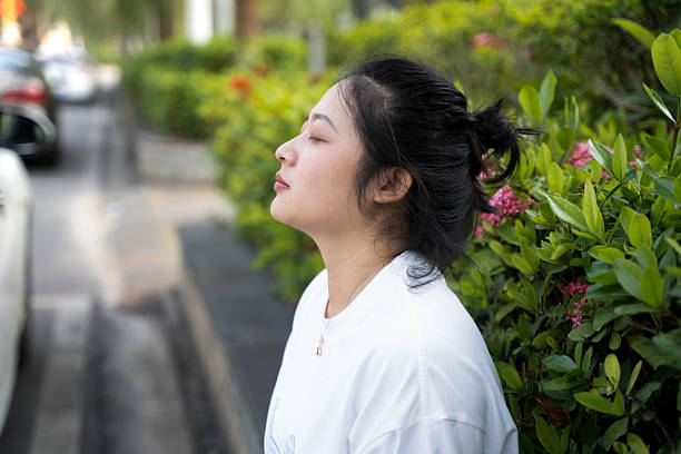 Close-up portrait in street at dusk of adorable Vietnamese lady with long hair looking away