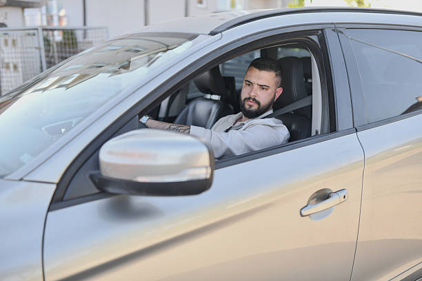 istock Focused Man Enjoys Calm Drive Looking Relaxed and Composed Behind the Wheel 2214046186