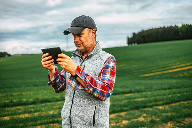 istock Farmer using digital tablet in lush green agricultural field 2214048194