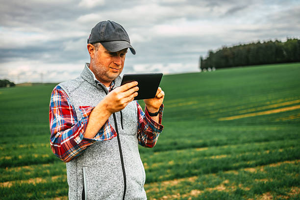 istock Farmer using digital tablet in lush green agricultural field 2214048208
