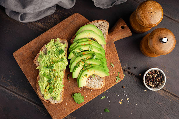 istock Vegan avocado toasts on wooden serving board 2214049548