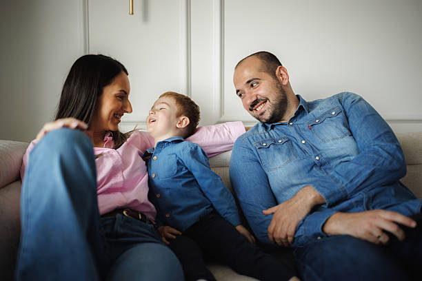 istock Parents Relaxing with Son on Couch 2214051283