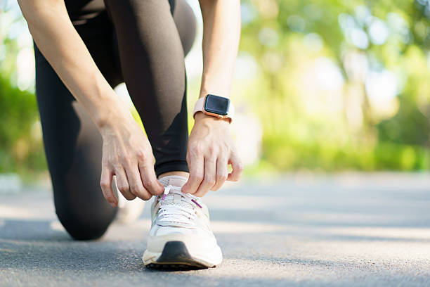 istock Woman tie a shoelace while running in the park. 2214054493