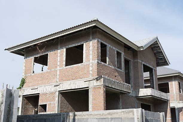 Construction of a residential home in an urban city. Home has the wood framework and walls built and is in progress.