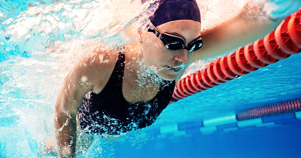 istock Swimming, training and athlete in pool, water and practice for competition, healthy and workout in morning. Sports, active and person with energy for performance, exercise and swimmer with routine 2214059090