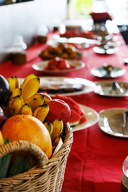 Fruit basket on a red tablecloth with plates arranged for an event