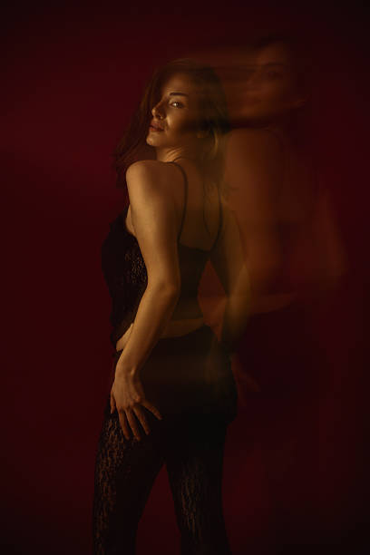 istock Sensual Woman Looking at Camera While Seductively Posing on Burgundy Background 2214063265