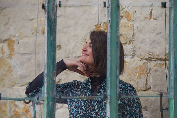 istock Young Elegant Woman Smiling Behind a Vintage Window Frame 2214065472