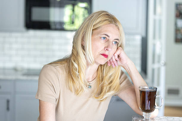 istock Middle Aged Woman Feeling Depressed in Kitchen With Cup of Tea 2214068958