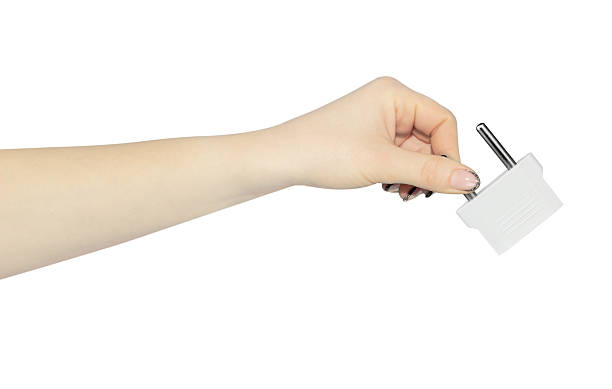istock adapter for American outlet in hand, outstretched hand with plug adapter, isolated from background 2214070072