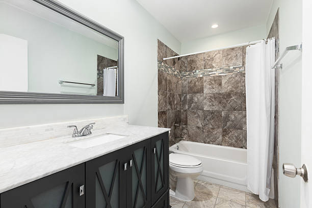 istock A bathroom with a grey cabinet and brown tiled shower. 2214070662