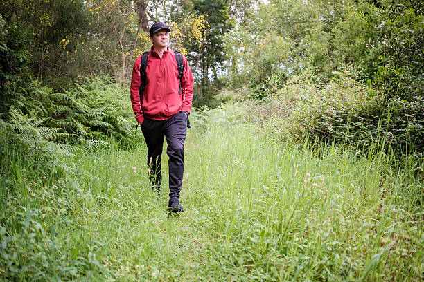 istock man hiking through a grassy path enjoying nature 2214071871