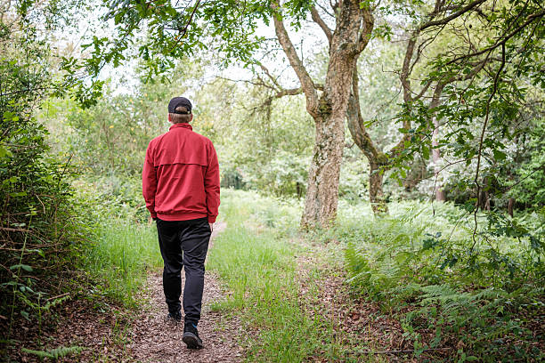 istock man walking on a path through green grass in a forest 2214071937