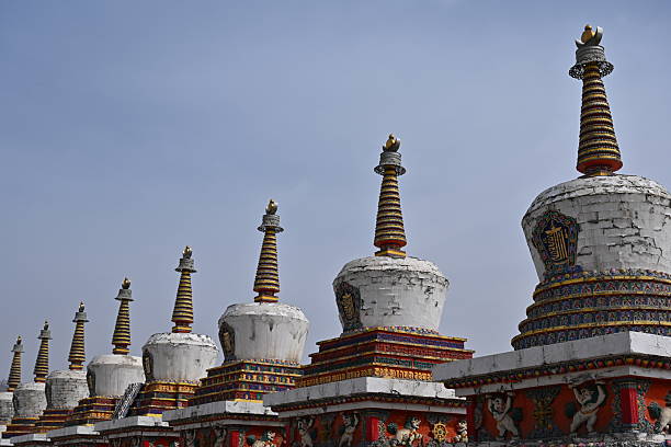 istock A serene white stupa rises against the mountain sky, its sunlit dome adorned with prayer flags fluttering sacred mantras into the wind. 2214072213