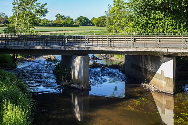 istock Concrete road bridge crossing calm river in rural landscape 2214072231