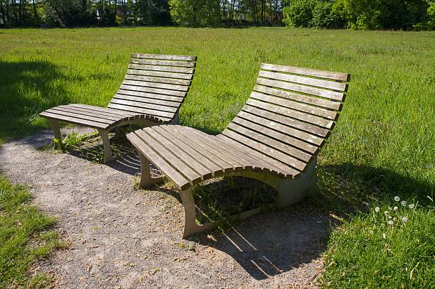 istock Two empty reclining benches inviting relaxation in green park 2214072233