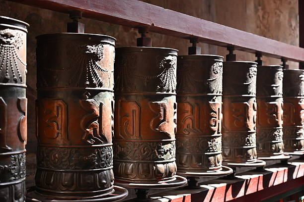 istock Golden prayer wheels glow in the soft light, their engraved mantras spinning with each devout turn, carrying blessings on the Himalayan breeze. 2214072768