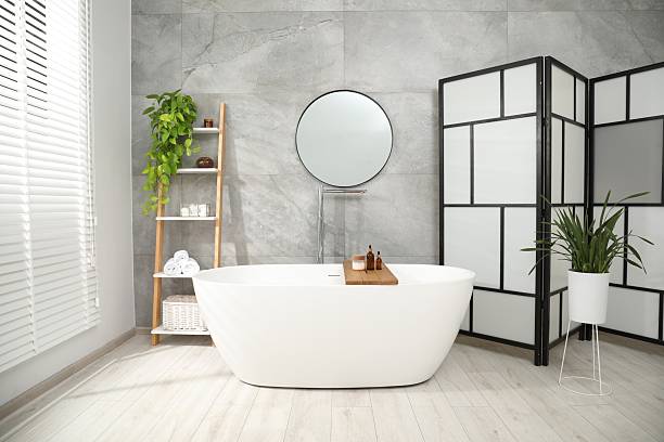 istock Folding screen, bathtub, houseplants and mirror in bathroom. Interior design 2214073587
