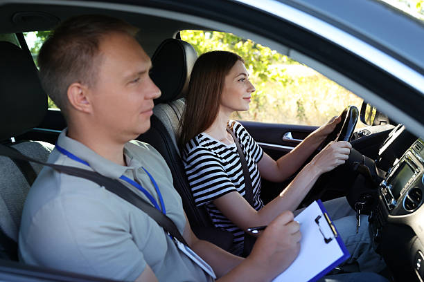 istock Driving school. Student passing driving test with examiner in car 2214073787