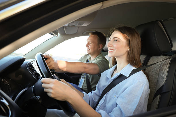 istock Driving school. Student passing driving test with examiner in car 2214073811