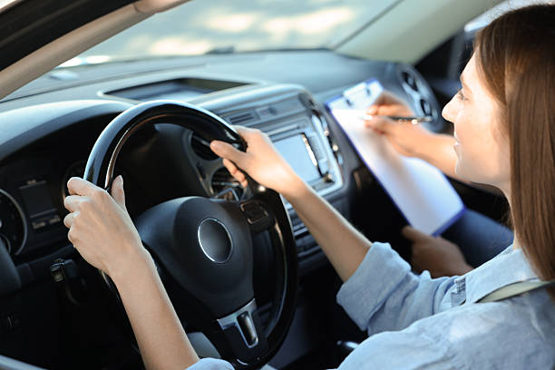 istock Driving school. Student passing driving test with examiner in car 2214073856
