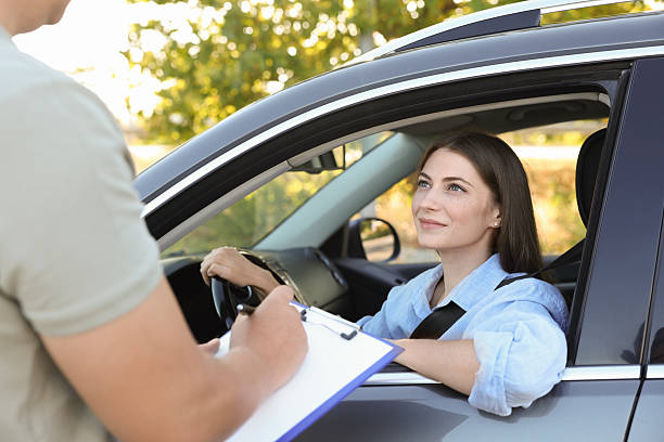 istock Examiner near car with student during test at driving school 2214073862