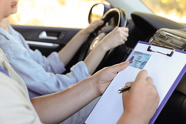 istock Driving school. Student passing driving test with examiner in car, closeup 2214073872