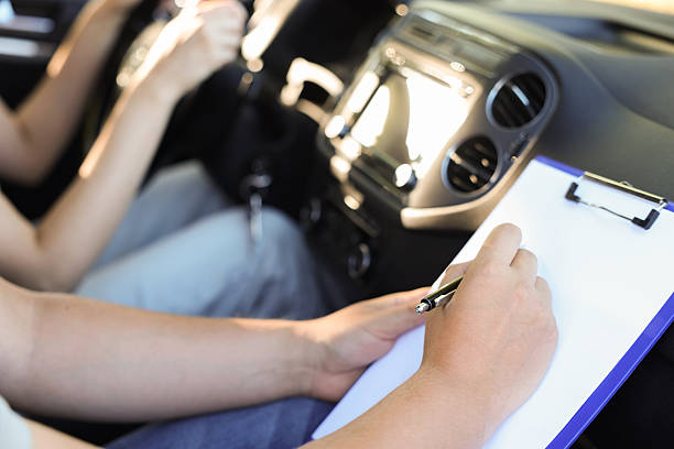 istock Driving school. Student passing driving test with examiner in car, closeup 2214073886