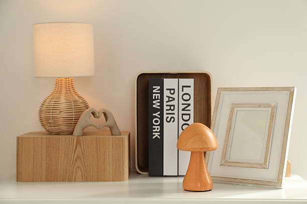 Beautiful decorative elements, books and lamp on white table