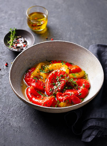 istock Marinated Roasted Peppers with Fresh Herbs in Salad Bowl. Grey background. Close up. 2214074409