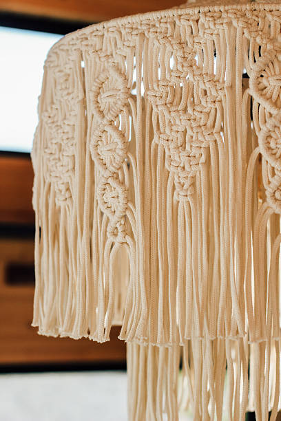 istock Unique macrame lamp shade showcasing intricate fringe design in warm interior setting 2214074988