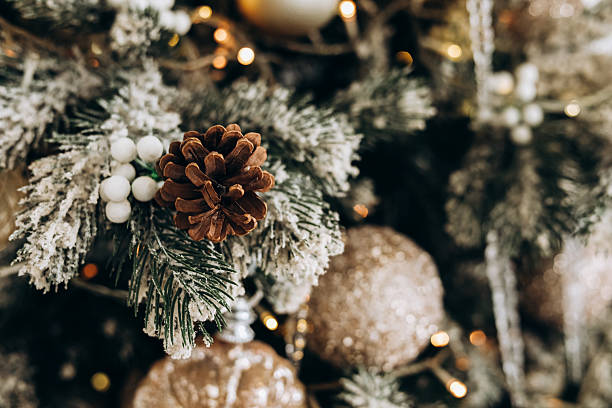 Decorative pine cone and festive ornaments create a warm holiday atmosphere on a Christmas tree