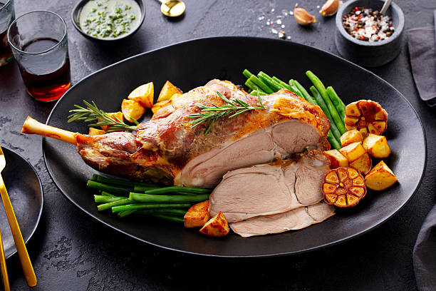 istock Roasted lamb leg with green bean and red wine. Grey background. Close up. 2214075274