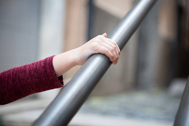 istock A persons hand is firmly gripping a sturdy metal railing for support 2214076232
