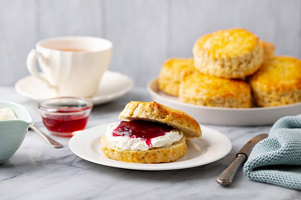 istock Scones with jam, clotted cream and cup of tea on marble table. Grey background. Close up. 2214076341