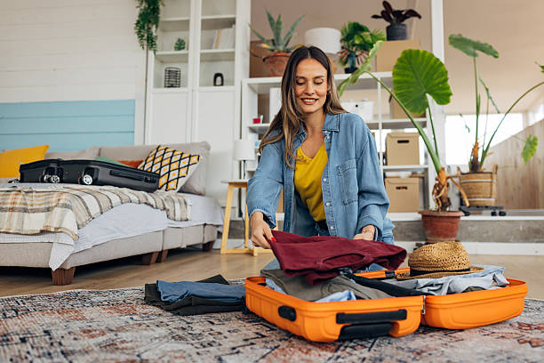 istock A woman arranges her wardrobe in a suitcase while packing for a summer trip 2214076608