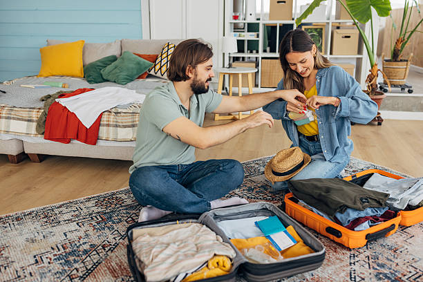 istock A woman and a man pack cosmetics in small packages into a suitcase 2214076624