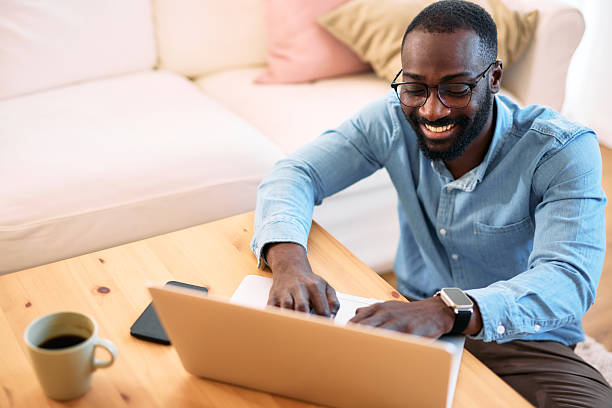istock Smiling young man working from home typing on laptop 2214076642