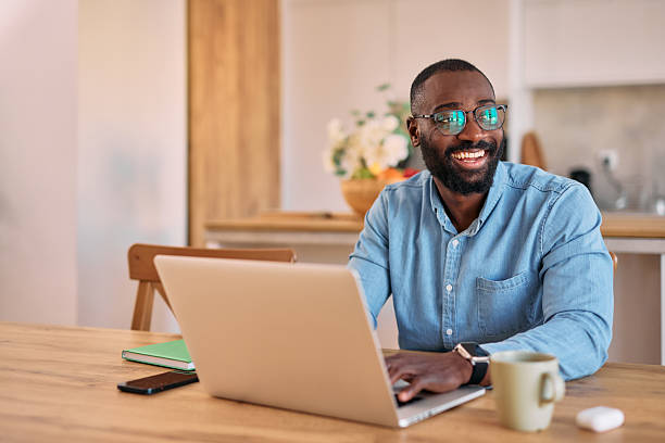 istock Young black man working from home smiling and looking away 2214076663