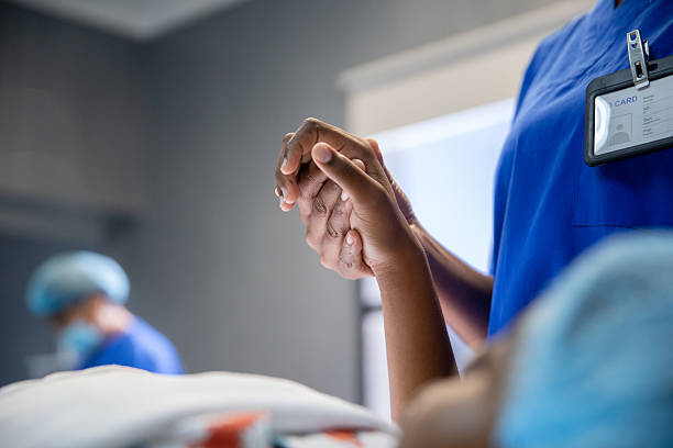 Female anaesthesiologists holding a young patient hand