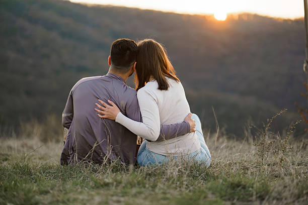 istock Embracing couple sitting on a mountain 2214077927