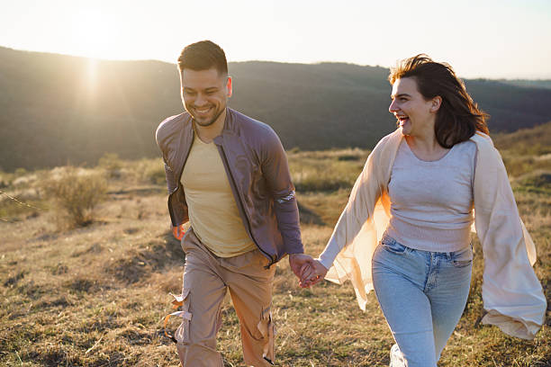 istock Carefree couple walking on a mountain at sunset 2214078708