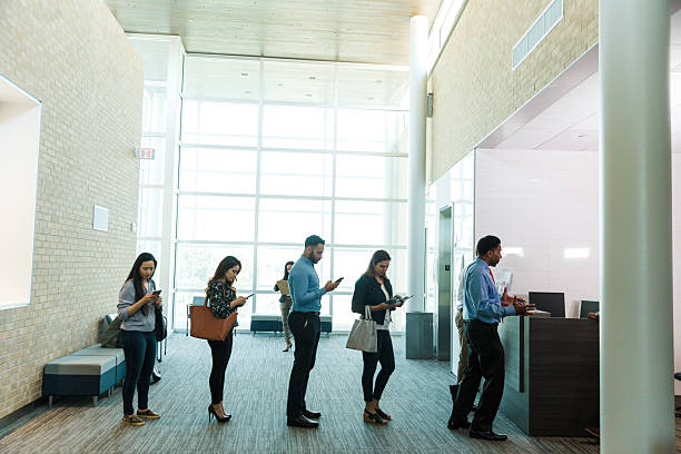istock Diverse Group of Adults Waiting in Line, Using Technology 2214081898