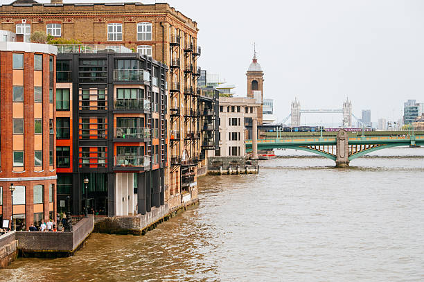 Buildings by the Thames river in London, with Tower Bridge in the background