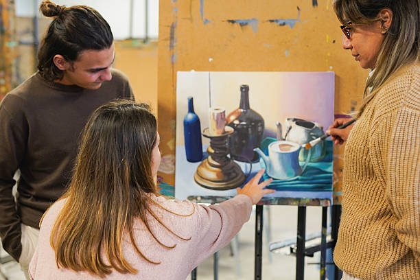 istock Mature female teacher working with university students inside art classroom - Young people and school concept 2214085855