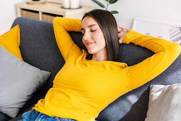 istock Young beautiful woman relaxing on comfortable sofa at bright modern apartment 2214085968