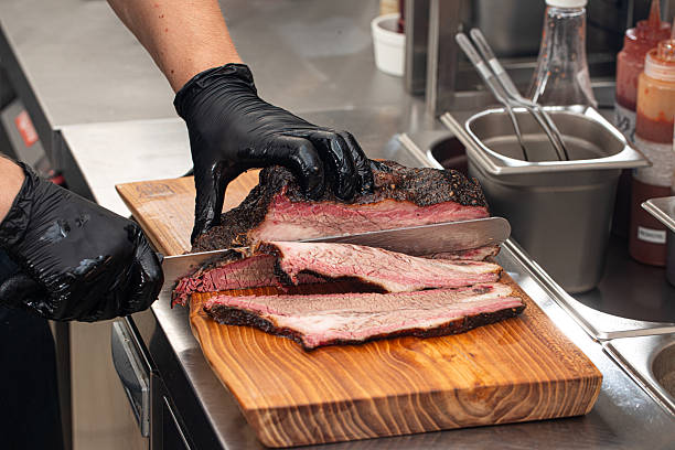 istock Cutting smoked brisket into slices in the kitchen 2214089491