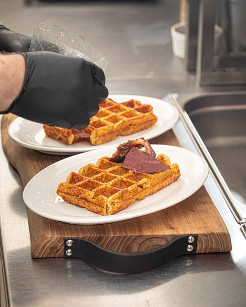 istock Chef putting pieces of beef brisket on waffles 2214089520